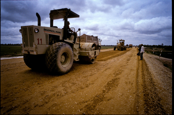 Heavy vehicle operator drives a road roller during the leveling and upgrading of a road in Cambodia. ADB Flickr